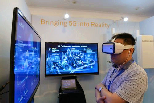 嘉賓在峰會(huì)現(xiàn)場利用VR設(shè)備觀看5G測試外場。